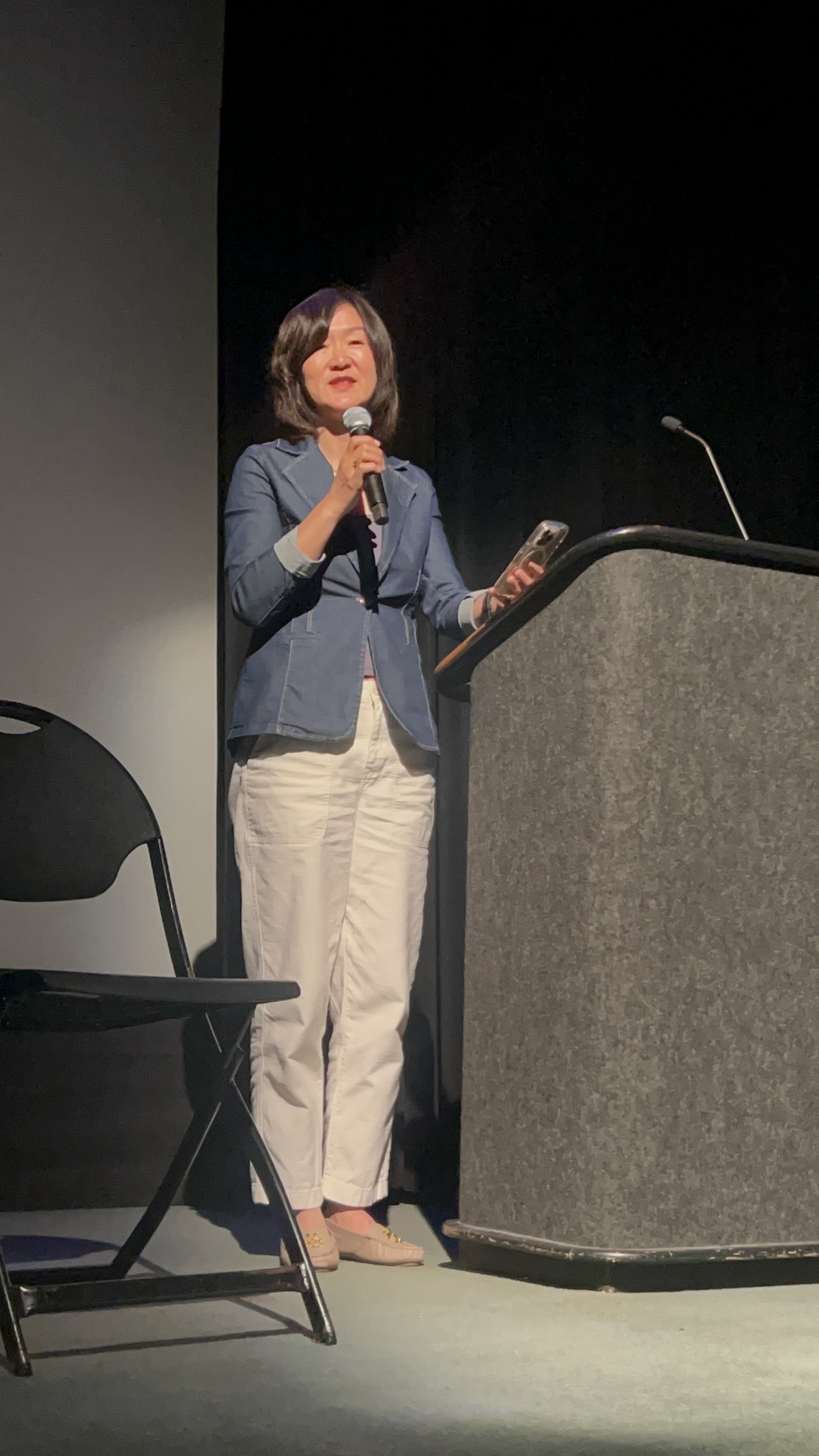 Coach Olivia speaking on stage at an event