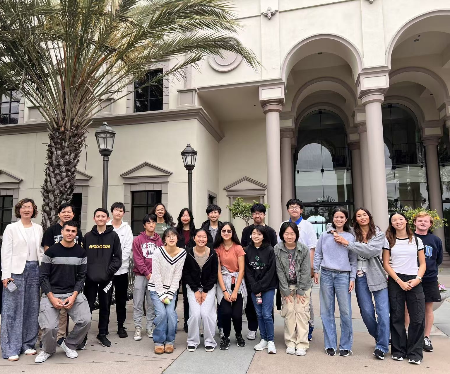 Coach Olivia with a group of students outside a university campus